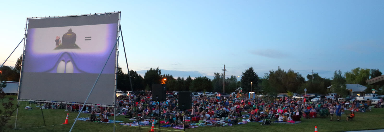 nighttime scene of crowd at outdoor movies in park